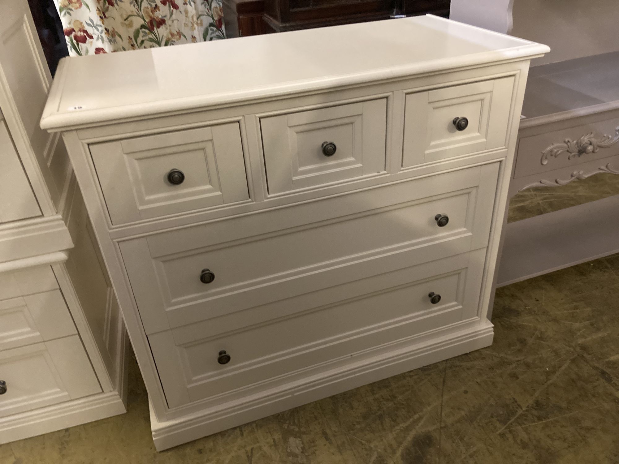 A contemporary white five drawer chest, together with a pair of matching three drawer bedside chests, larger width 105cm depth 50cm hei